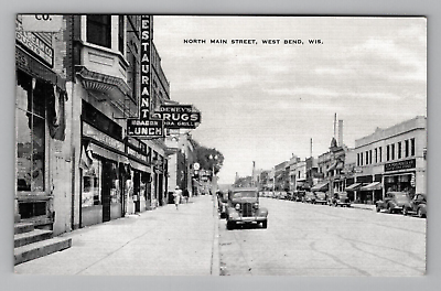 #ad Postcard 1900s WI North Main Street Cars Stores Signs Woman West Bend Wisconsin